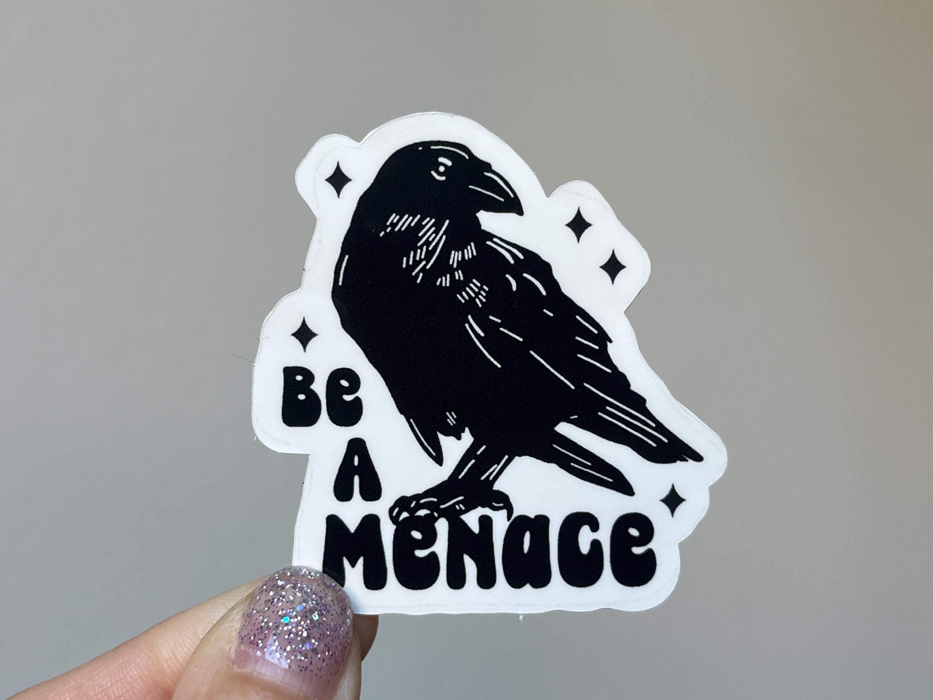 A white sticker with a black bird and black text that reads "be a menace"